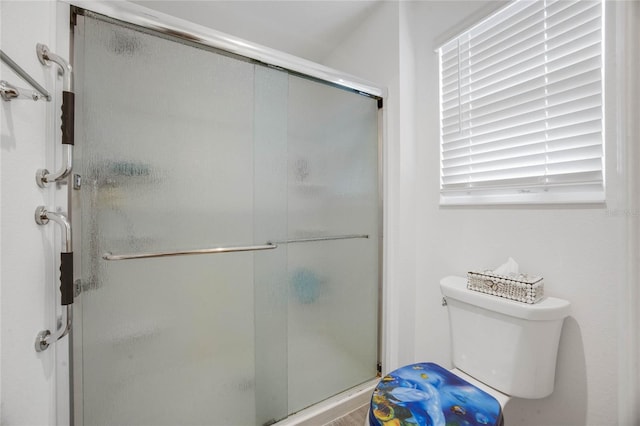 bathroom featuring toilet and an enclosed shower