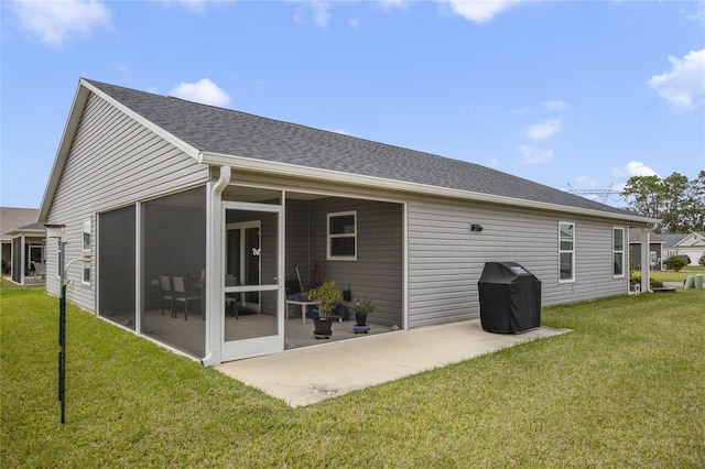 rear view of house featuring a yard, a patio area, and a sunroom