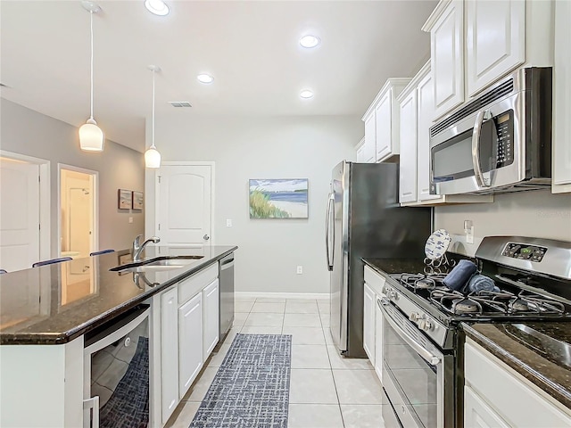 kitchen with sink, white cabinets, beverage cooler, and appliances with stainless steel finishes