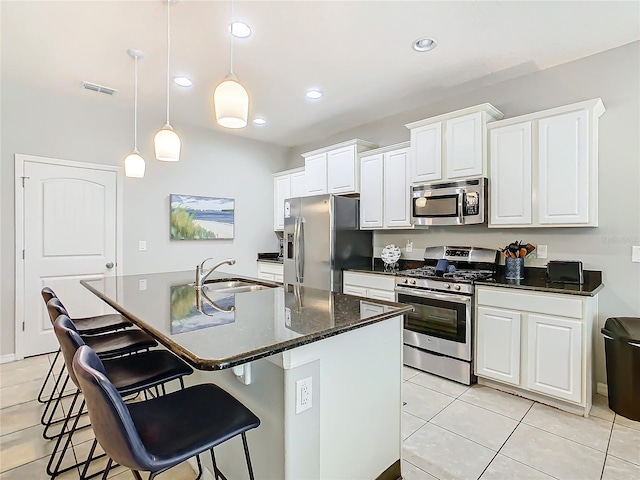 kitchen featuring sink, hanging light fixtures, a center island with sink, white cabinets, and appliances with stainless steel finishes