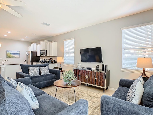 living room with light tile patterned floors, sink, a wealth of natural light, and ceiling fan