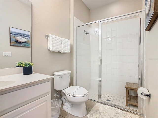 bathroom with tile patterned flooring, toilet, vanity, and walk in shower