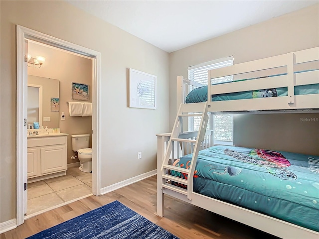 bedroom featuring connected bathroom and light hardwood / wood-style flooring