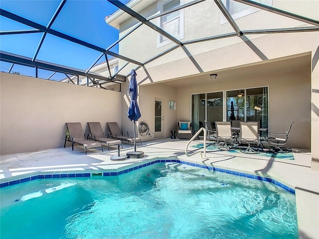 view of swimming pool with a patio area and glass enclosure