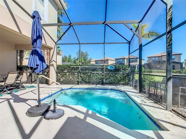 view of swimming pool featuring glass enclosure and a patio area