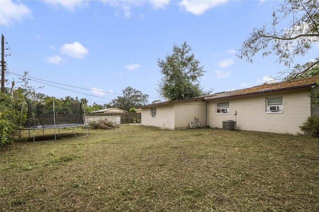 view of yard featuring central AC unit and a trampoline