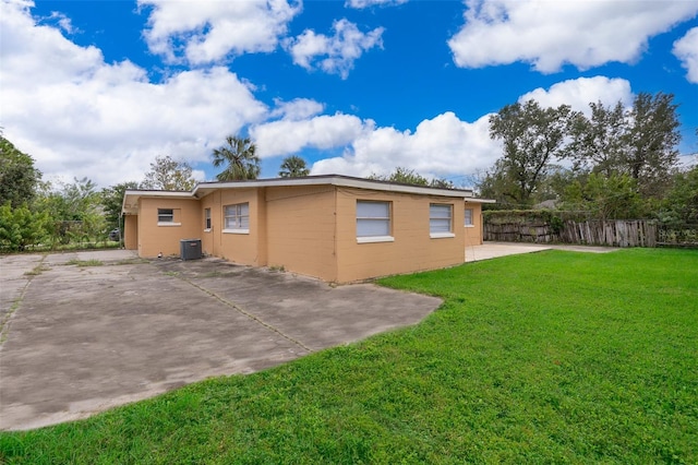 view of side of property featuring a lawn, cooling unit, and a patio area