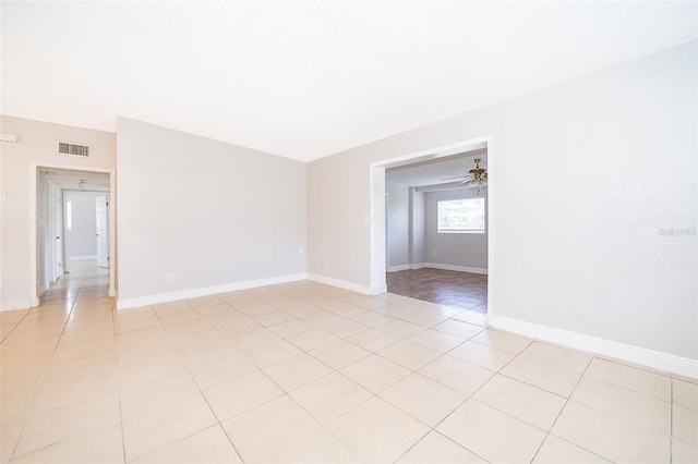 spare room with ceiling fan and light tile patterned flooring