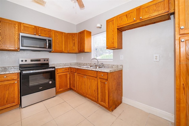 kitchen with ceiling fan, sink, light tile patterned floors, and stainless steel appliances