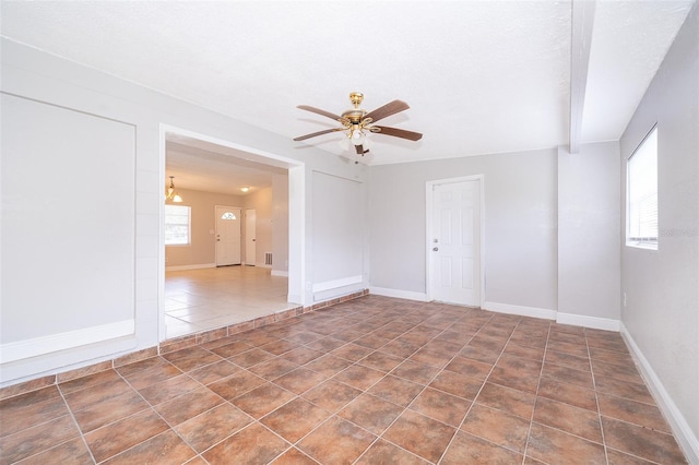 tiled empty room featuring ceiling fan and a textured ceiling