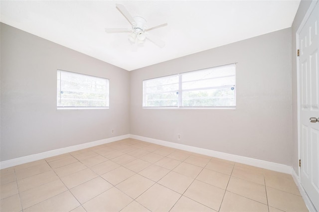 tiled spare room with plenty of natural light, ceiling fan, and lofted ceiling