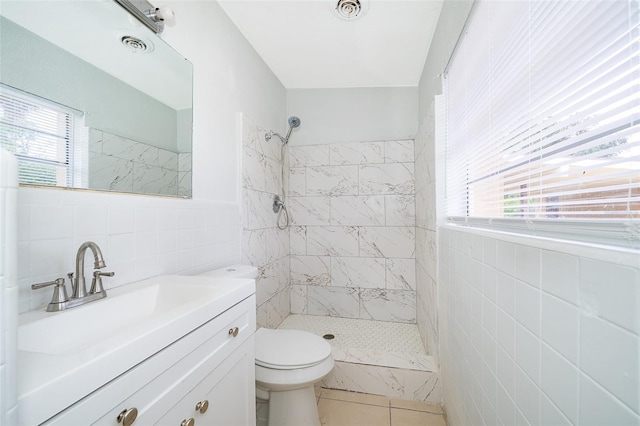 bathroom with toilet, plenty of natural light, and tile walls