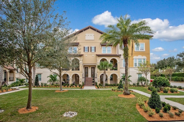 mediterranean / spanish home with french doors and a front lawn