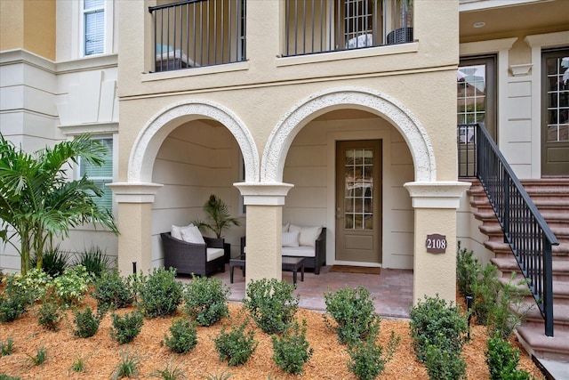 view of exterior entry featuring an outdoor living space and a patio area