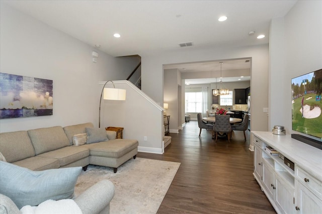 living room featuring dark hardwood / wood-style floors and an inviting chandelier