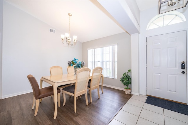 dining room with light hardwood / wood-style floors, lofted ceiling, and an inviting chandelier