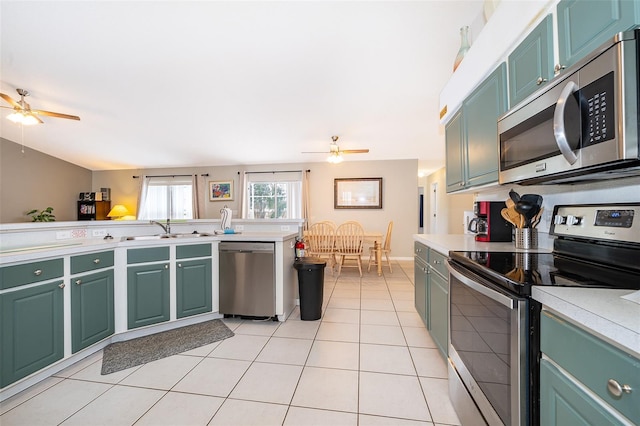 kitchen featuring light tile patterned flooring, appliances with stainless steel finishes, ceiling fan, and sink