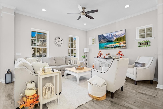 living room featuring light hardwood / wood-style floors, ceiling fan, and ornamental molding