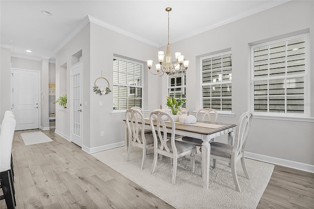 dining space featuring crown molding, light hardwood / wood-style floors, and a notable chandelier