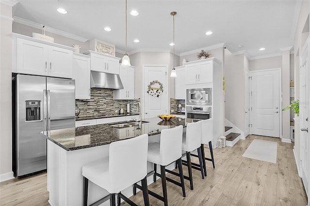 kitchen with pendant lighting, a center island with sink, light hardwood / wood-style floors, white cabinetry, and stainless steel appliances