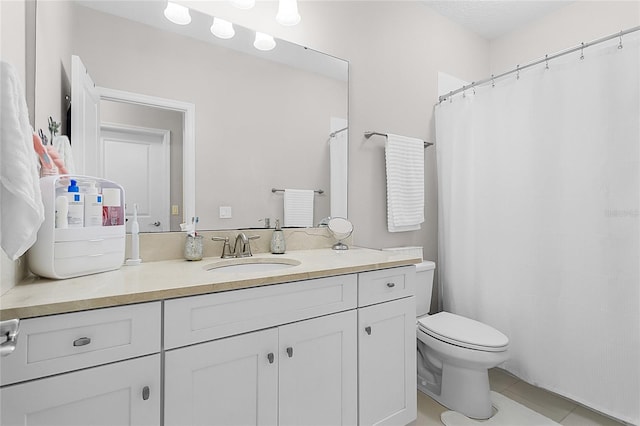 bathroom with tile patterned flooring, vanity, and toilet