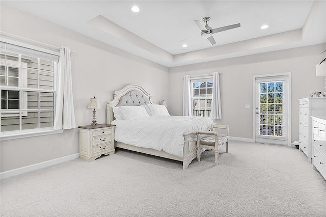 carpeted bedroom featuring a raised ceiling, access to exterior, and ceiling fan