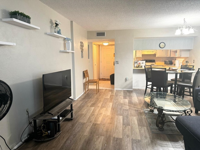 dining room featuring an inviting chandelier, a textured ceiling, and light hardwood / wood-style flooring