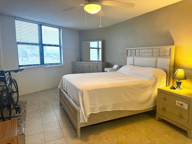 tiled bedroom featuring ceiling fan and a textured ceiling