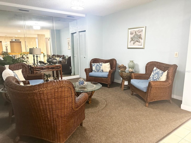 living area with carpet flooring and a textured ceiling