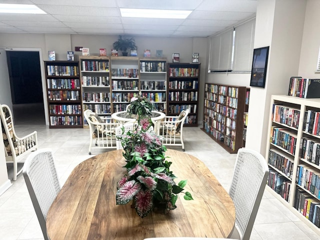 tiled dining area with a paneled ceiling