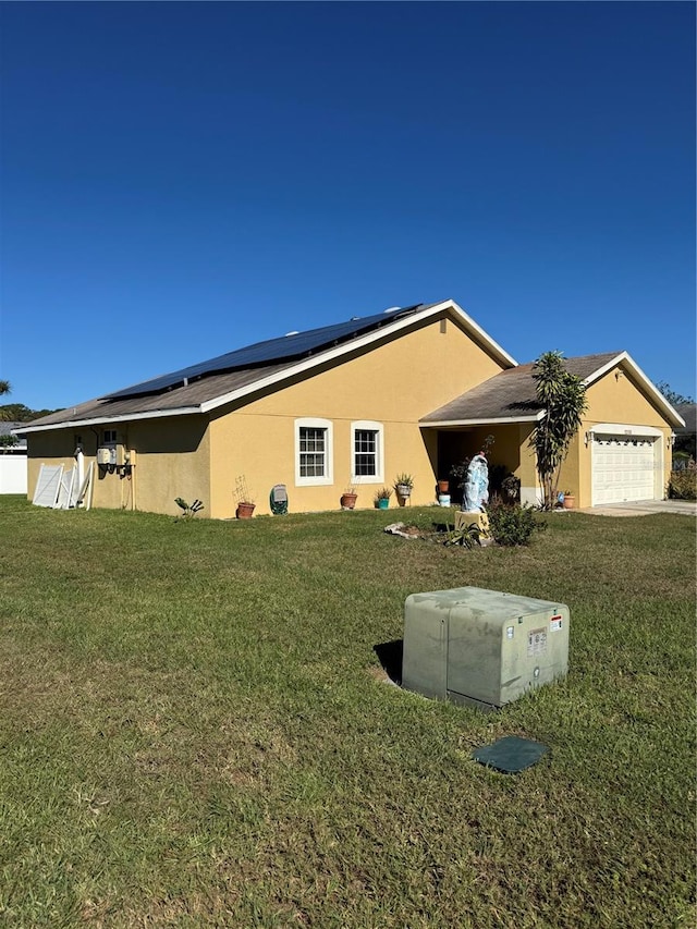 view of side of property featuring solar panels, a garage, and a yard