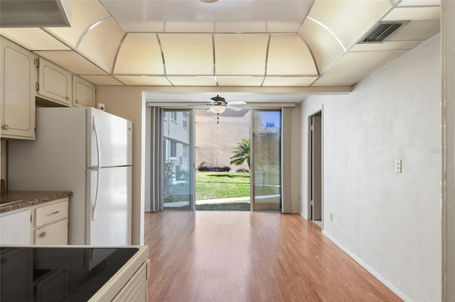 kitchen with white fridge, light hardwood / wood-style floors, range, and ceiling fan