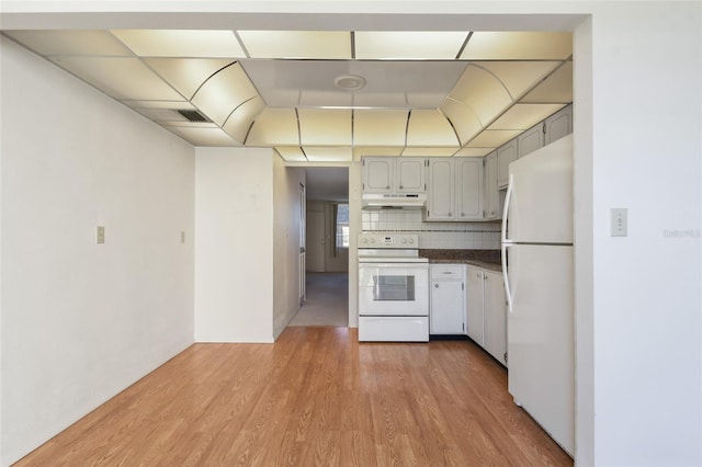 kitchen with hardwood / wood-style floors, white appliances, gray cabinetry, and backsplash