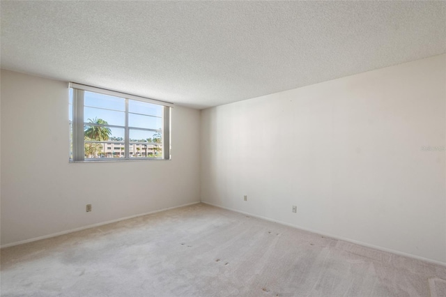 carpeted spare room with a textured ceiling