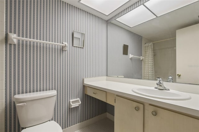 bathroom with curtained shower, vanity, and toilet