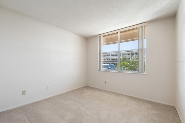 carpeted empty room featuring a textured ceiling