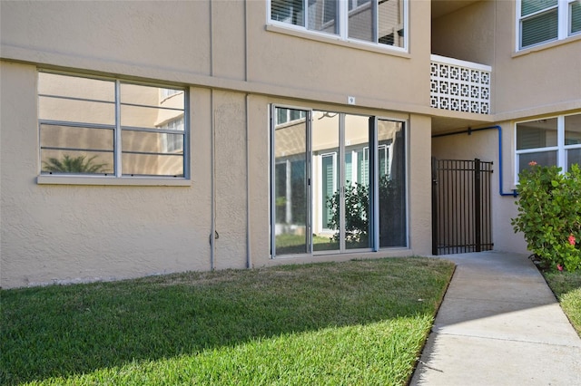 view of exterior entry featuring a lawn