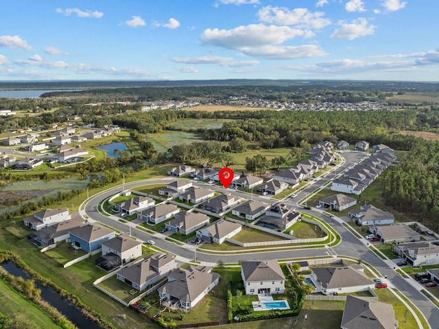 aerial view featuring a residential view, a wooded view, and a water view