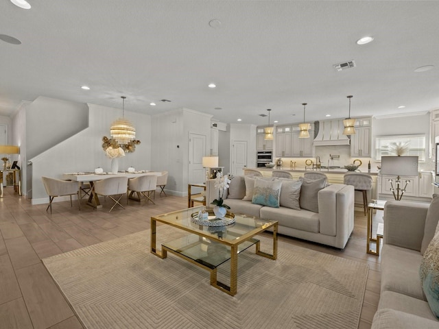 living area featuring wood finish floors, visible vents, ornamental molding, recessed lighting, and baseboards