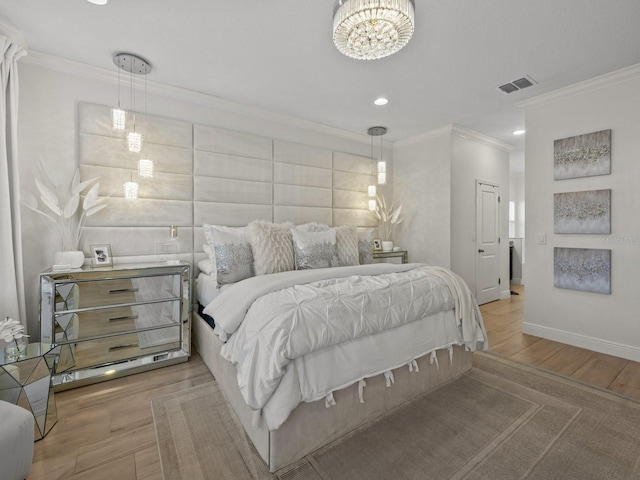 bedroom with visible vents, baseboards, wood finished floors, and crown molding