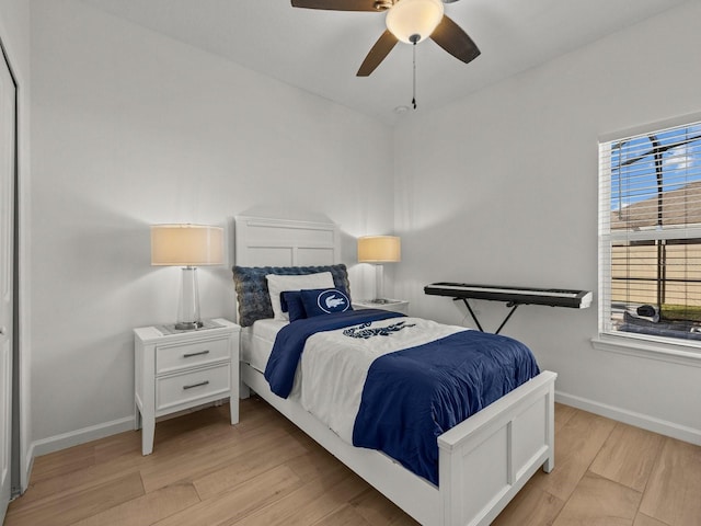 bedroom with a ceiling fan, baseboards, and wood finished floors