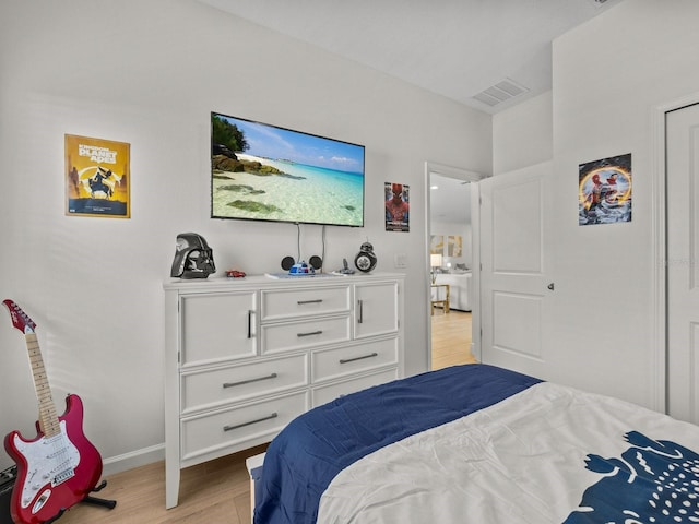 bedroom featuring light wood-style flooring, baseboards, and visible vents