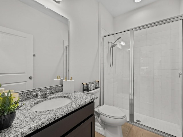 bathroom featuring vanity, toilet, and a shower stall