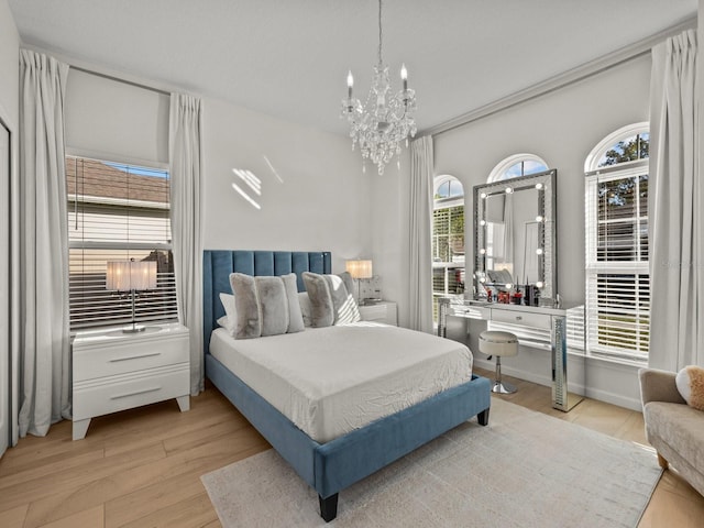 bedroom featuring a notable chandelier, wood finished floors, and baseboards