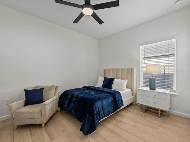 bedroom featuring light wood-type flooring, baseboards, and ceiling fan