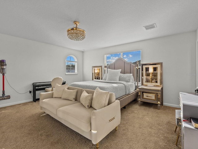 carpeted bedroom with visible vents, a textured ceiling, and baseboards