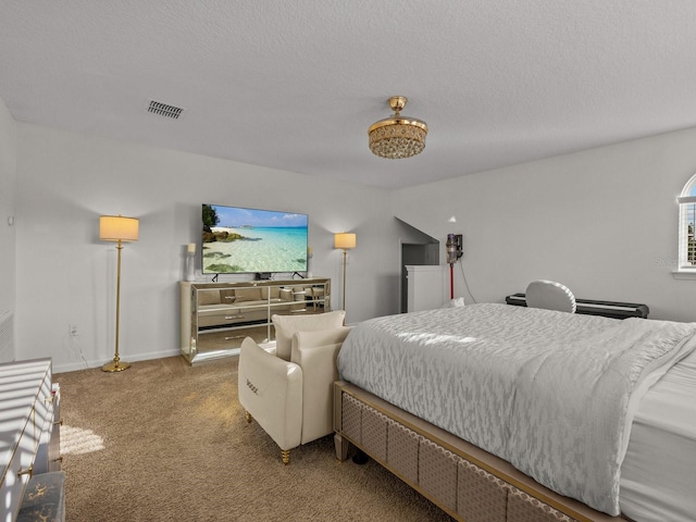 carpeted bedroom with visible vents, a textured ceiling, and baseboards