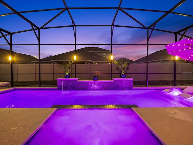 view of swimming pool featuring glass enclosure, a fenced in pool, and fence