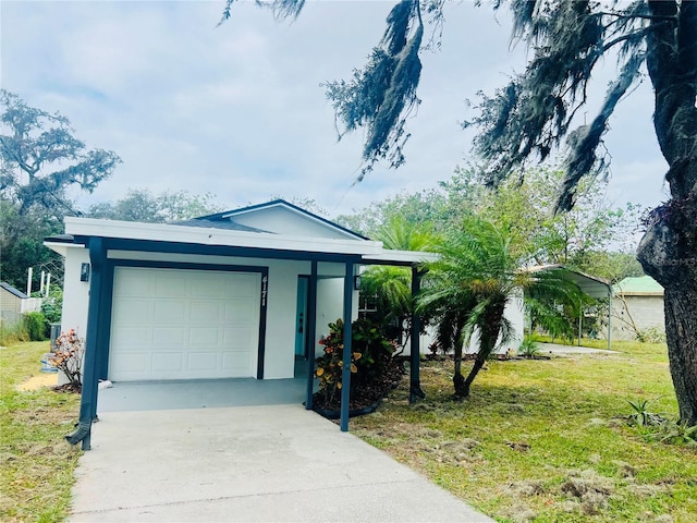 view of front of home with a carport, a garage, and a front lawn