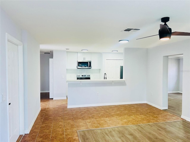 unfurnished living room with ceiling fan and light hardwood / wood-style floors